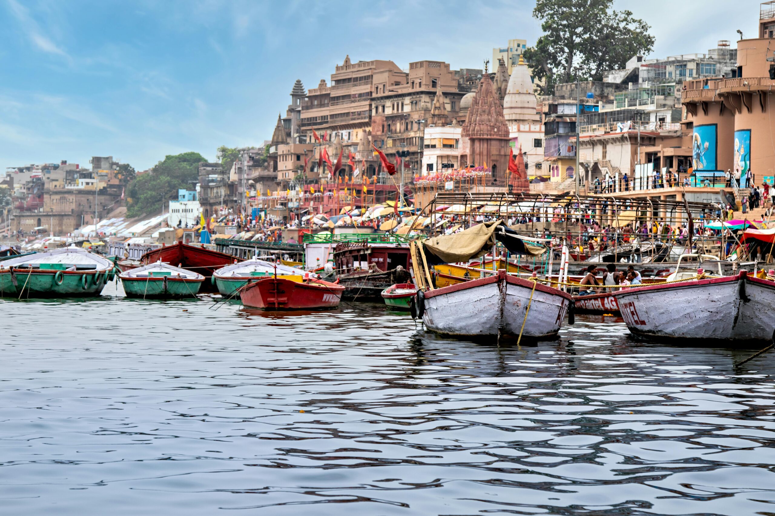 Vibrant boats aligned along Varanasi's iconic riverbank, showcasing urban life by the Ganges.