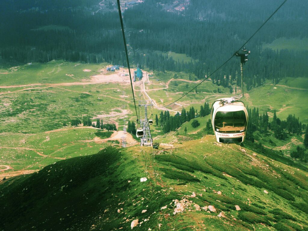 Experience a breathtaking aerial view riding the Gulmarg Gondola in Kashmir's stunning landscape.